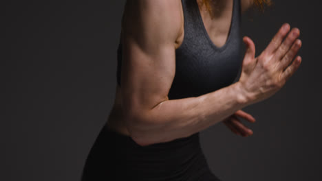 Close-Up-Studio-Shot-Of-Mature-Woman-Wearing-Gym-Fitness-Clothing-Doing-Cardio-Exercise-Running-On-The-Spot